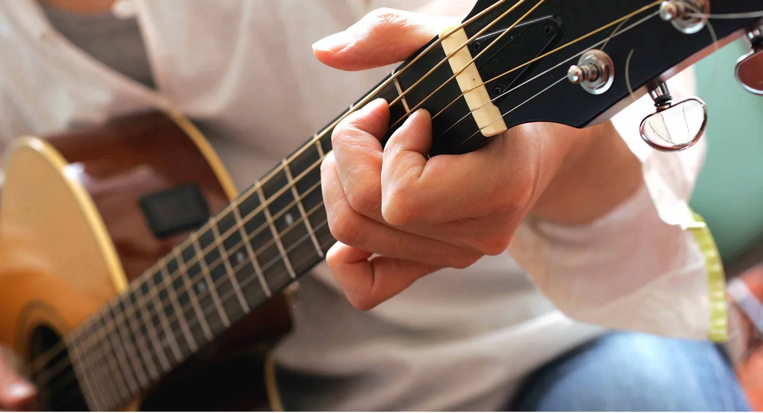 Hands playing an acoustic guitar