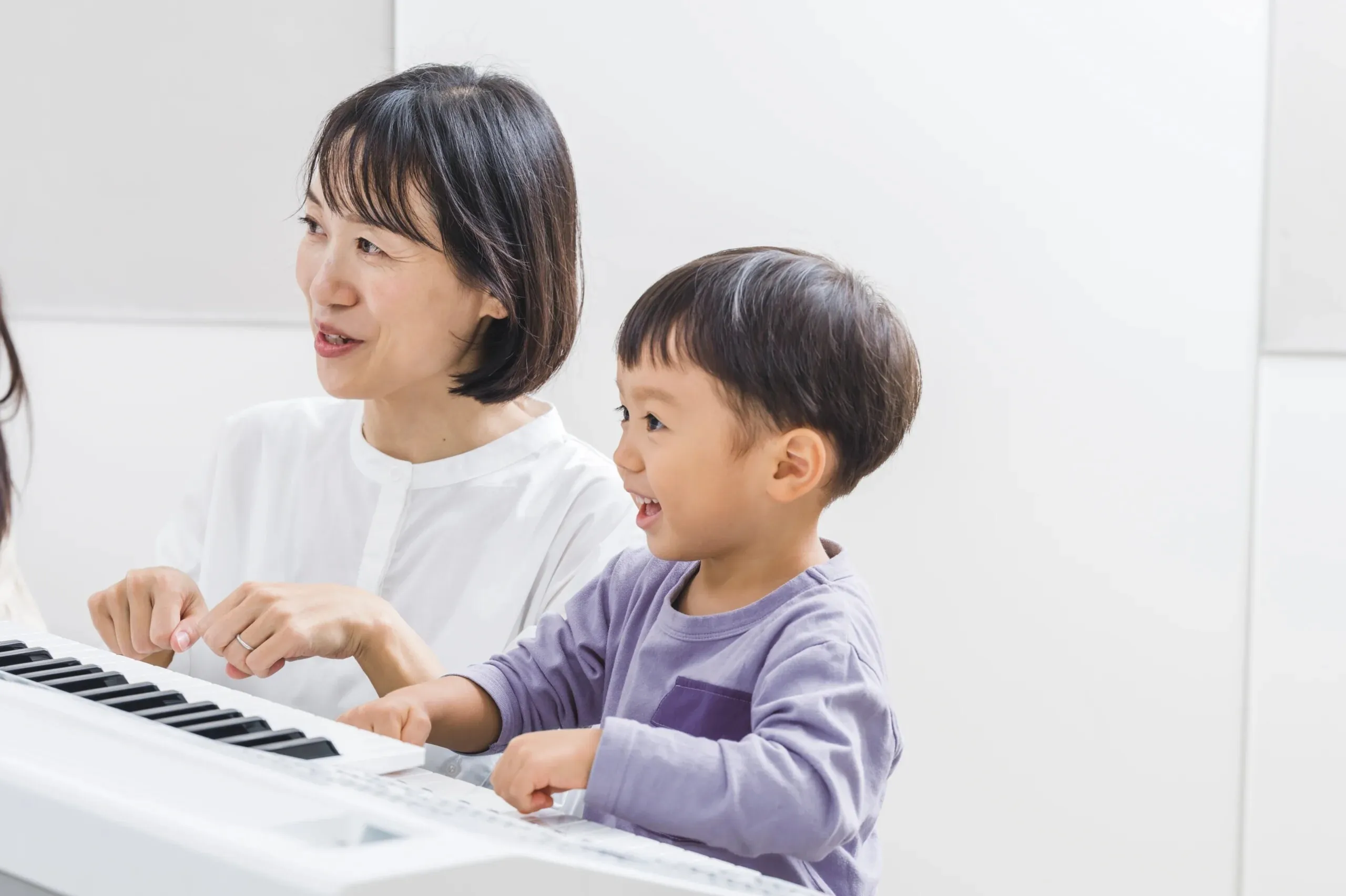 A parent and toddler at a keyboard together