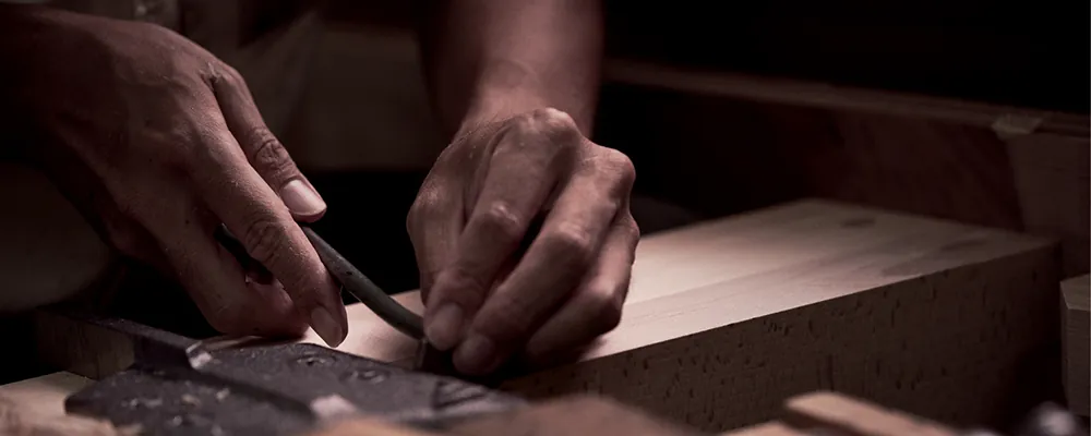 A Yamaha craftsman shaping wood by hand